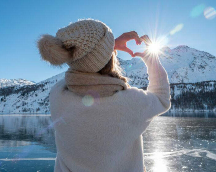 Femme de dos dans un paysage enneigé, passe l'hiver sereinement grâce aux bienfaits de la chromothérapie